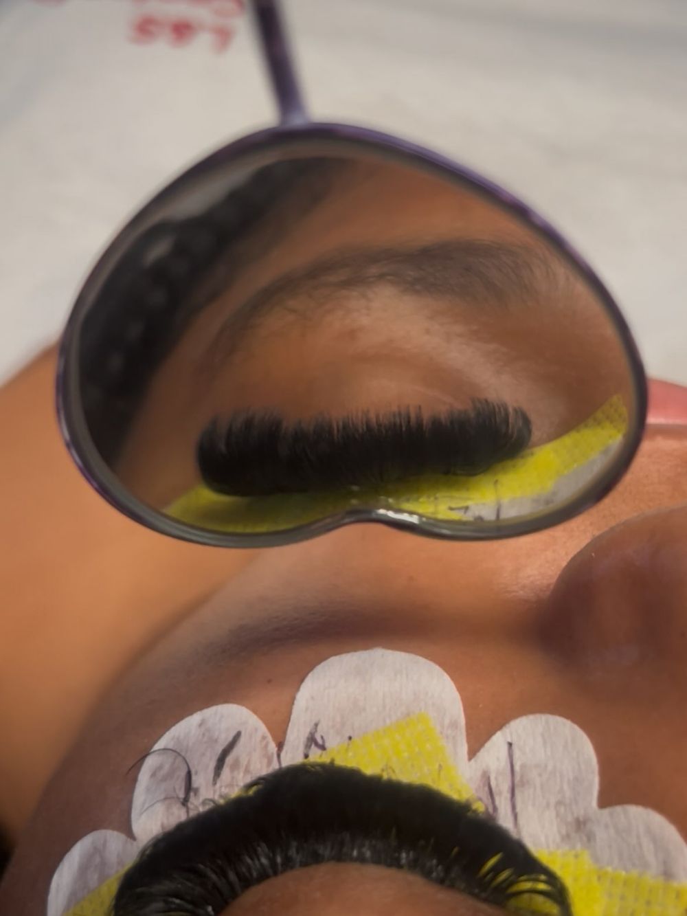 Lash set with yellow tape under a heart mirror