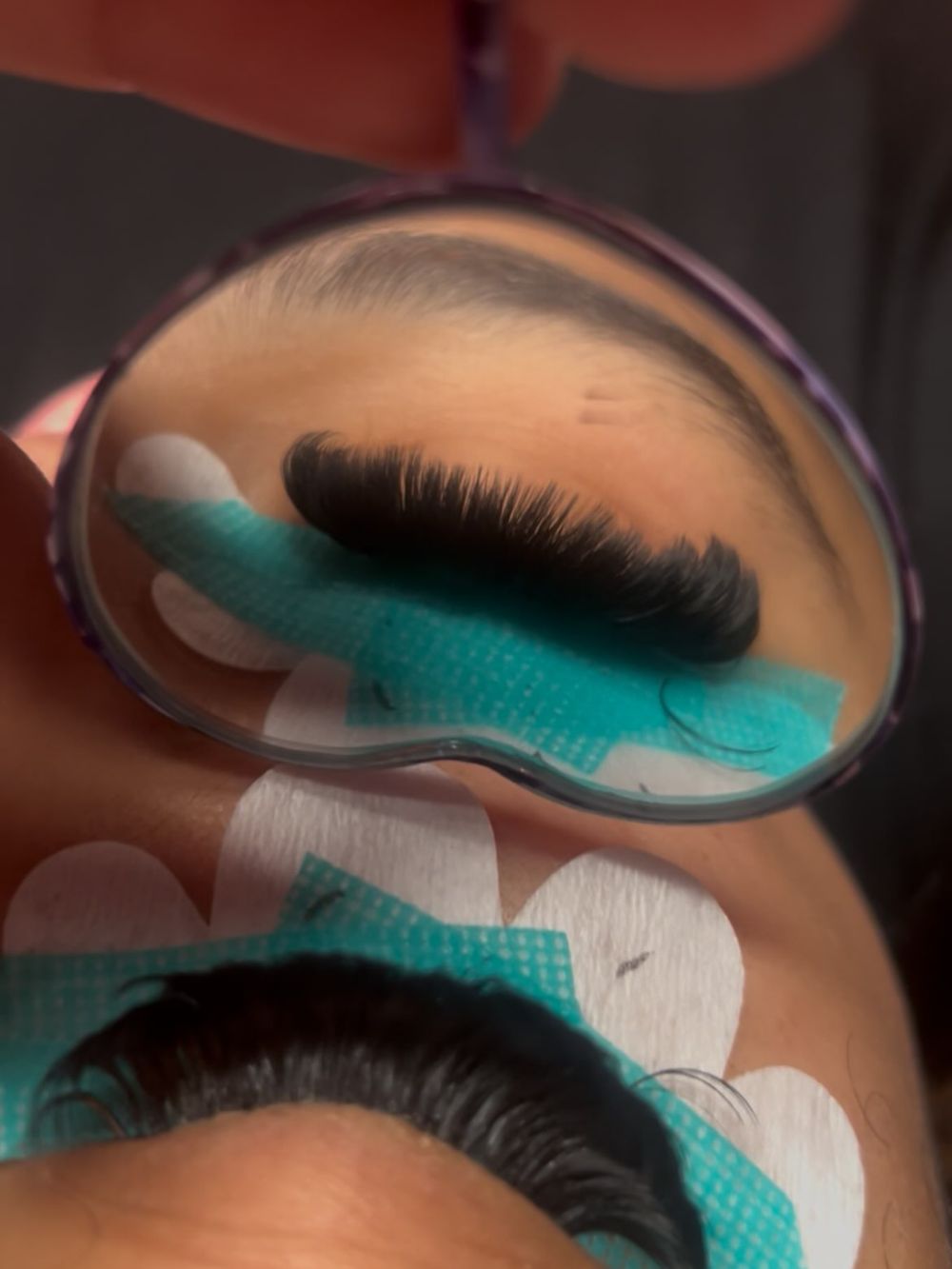 Lash set with teal tape in a heart mirror