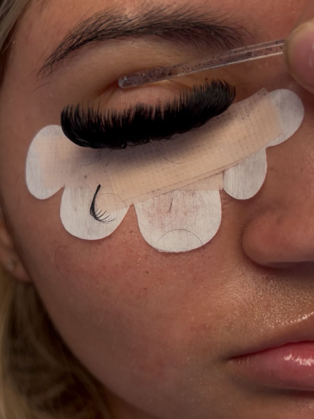 Dark lash set being checked with a wand